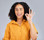 Perfect, happy and portrait of a winking woman isolated on a white background in a studio. Smile, review and girl with a hand gesture for satisfaction, happiness and okay emoji icon on a backdrop