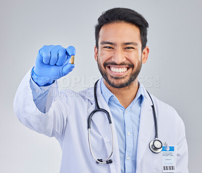 Buy stock photo Happy, portrait and doctor with pill in studio, smile for medicine, vitamin or cure on grey background. Medical, innovation and face of male healthcare expert with futuristic health supplement