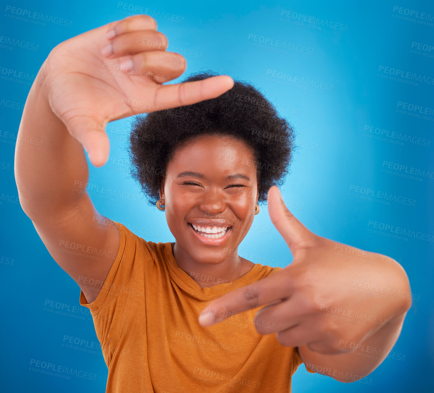 Buy stock photo Finger framing, portrait and happy black woman on blue background, studio and backdrop. Face, female and hands frame perspective, pose and smile of happiness, photography or capture profile picture