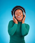 Happy, music and headphones with black woman in studio for streaming, singing and relax. Online radio, technology and listening with female isolated on blue background for hip hop and subscription
