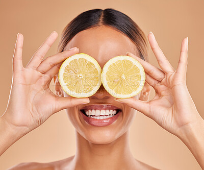 Buy stock photo Lemon on eyes, skincare and face of woman with smile in studio for wellness, facial treatment and natural cosmetics. Beauty, spa and happy girl with fruit slice for detox, vitamin c and dermatology
