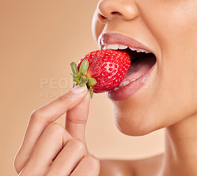 Buy stock photo Healthy, eating and a woman taking a bite of a strawberry while isolated on a studio background. Health, organic and a girl tasting a fruit for nutrition, diet or hunger for a snack on a backdrop