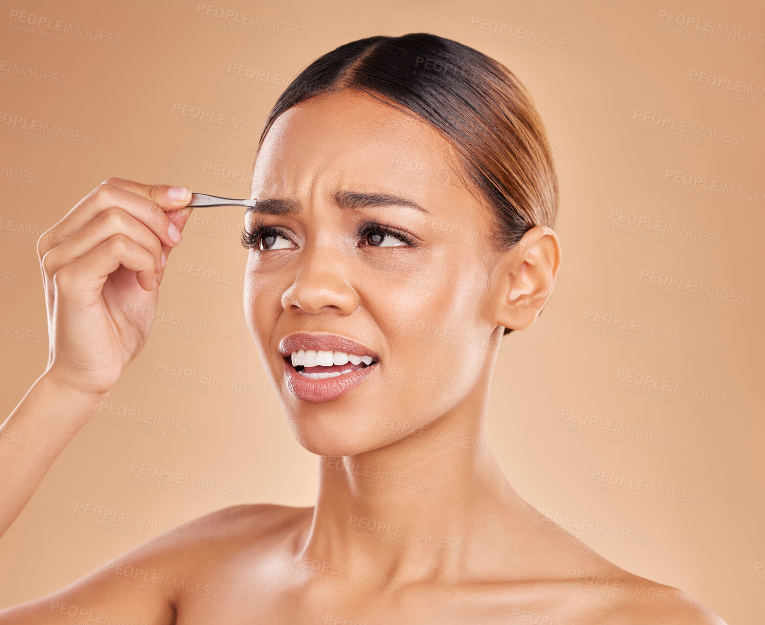 Buy stock photo Beauty, pain and eyebrows with woman and tweezers in studio for clean, self care and cosmetics. Facial, plucking and shape with female model on brown background for hair removal, skincare or grooming