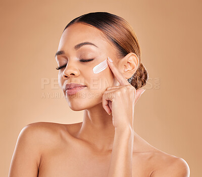 Buy stock photo Face, beauty skincare and woman with cream in studio isolated on a brown background. Dermatology, cosmetics and mixed race female model with lotion, creme or facial moisturizer product of skin health