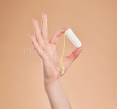 Buy stock photo Menstruation, showing and hand with a tampon isolated on a studio background. Healthcare, gynecology and woman holding a feminine product for bleeding, menstrual cycle and protection during period