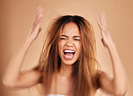Anger, screaming and woman with hair loss in studio isolated on a brown background. Haircare, damage and upset female model shouting after salon treatment fail, split ends or messy hairstyle problem