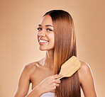 Woman, beauty and brushing hair portrait for growth and shine for healthy texture on a brown background. Smile of aesthetic female in studio with brush for natural keratin treatment haircare results