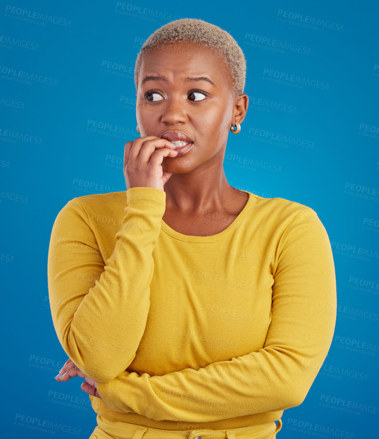 Buy stock photo Nervous, worried and scared black woman in fear and bitting nails isolated against a studio blue background. Mental health, anxiety and anxious female in terror feeling confused, problem and crisis