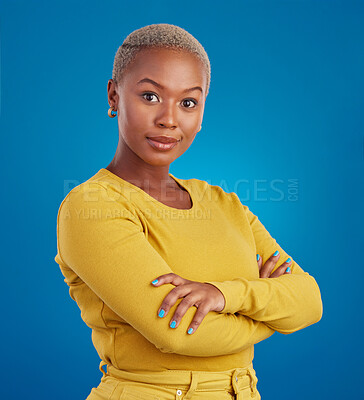 Buy stock photo Portrait, fashion and arms crossed with a black woman on a blue background in studio feeling confident. Serious, focus or empowerment and an attractive young female looking proud with confidence