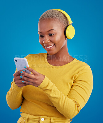 Buy stock photo Happy, phone and music with black woman in studio for streaming, multimedia and browsing. Search, smile and audio with female and headphones on blue background for listening, online radio and songs
