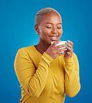 Black woman, happy and coffee or tea smell in studio with a smile and happiness. African female model with a drink and hands on cup to relax with a positive mindset on blue background with beauty