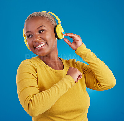Buy stock photo Black woman, headphones and listening to music with a smile in studio while happy streaming audio. African female model on a blue background to listen to radio, podcast or sound with a positive mood