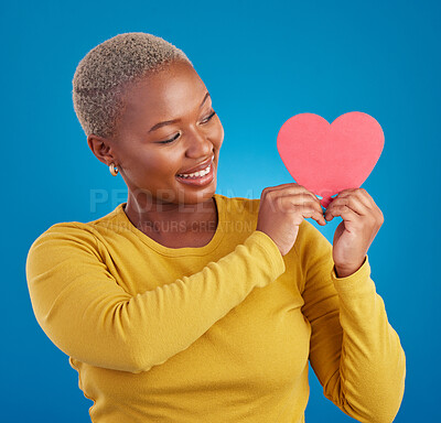 Buy stock photo Paper, heart and happy with black woman in studio for love, date and kindness. Invitation, romance and feelings with female and shape isolated on blue background for emotion, support and affectionate