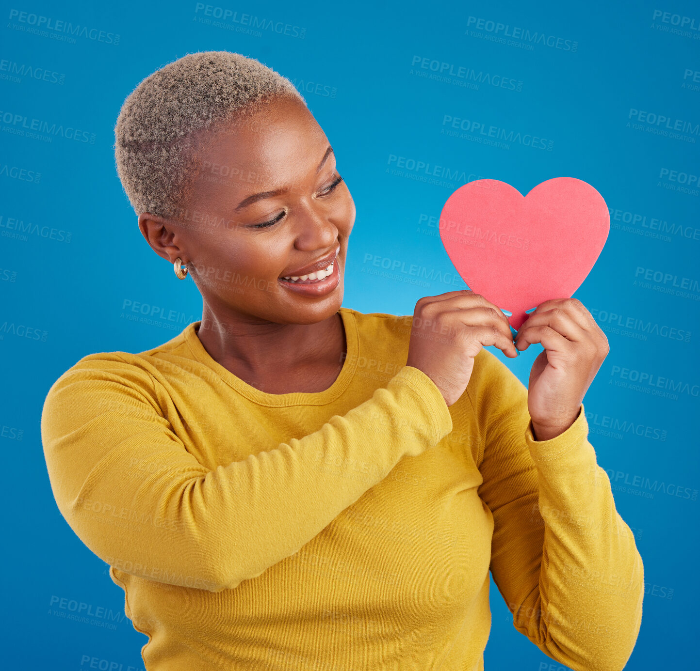 Buy stock photo Paper, heart and happy with black woman in studio for love, date and kindness. Invitation, romance and feelings with female and shape isolated on blue background for emotion, support and affectionate