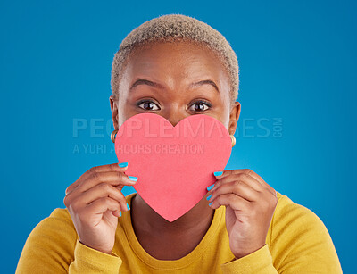 Buy stock photo Paper, heart and shy with black woman in studio for love, date and kindness. Invitation, romance and feelings with female and shape isolated on blue background for emotion, support and affectionate