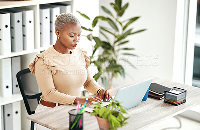 Buy stock photo Serious black woman, laptop and business at desk, online research and planning strategy. Young female worker typing on computer technology for administration, digital management and project update 