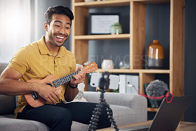 Buy stock photo Phone, guitar tutorial and man with a smile online to coach during live streaming lesson. Asian male influencer happy on home sofa with a ukulele as content creator teaching music on education blog