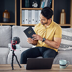 Christian man, bible and study with phone and microphone online while live streaming. Asian male on home sofa with holy book on religion as blog content creator or influencer teaching on podcast