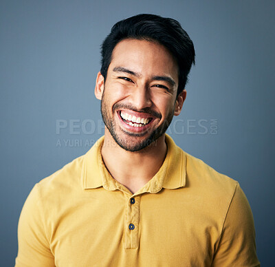 Buy stock photo Portrait, happy and carefree with a man in studio on a blue background feeling confident or positive. Face, smile and cheerful with a handsome young male posing on a color wall looking relaxed