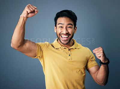 Indian man, celebrate and fist in studio portrait for winning mindset, happiness or achievement by background. Young model, male student or celebration with happy, excited face or winning for success
