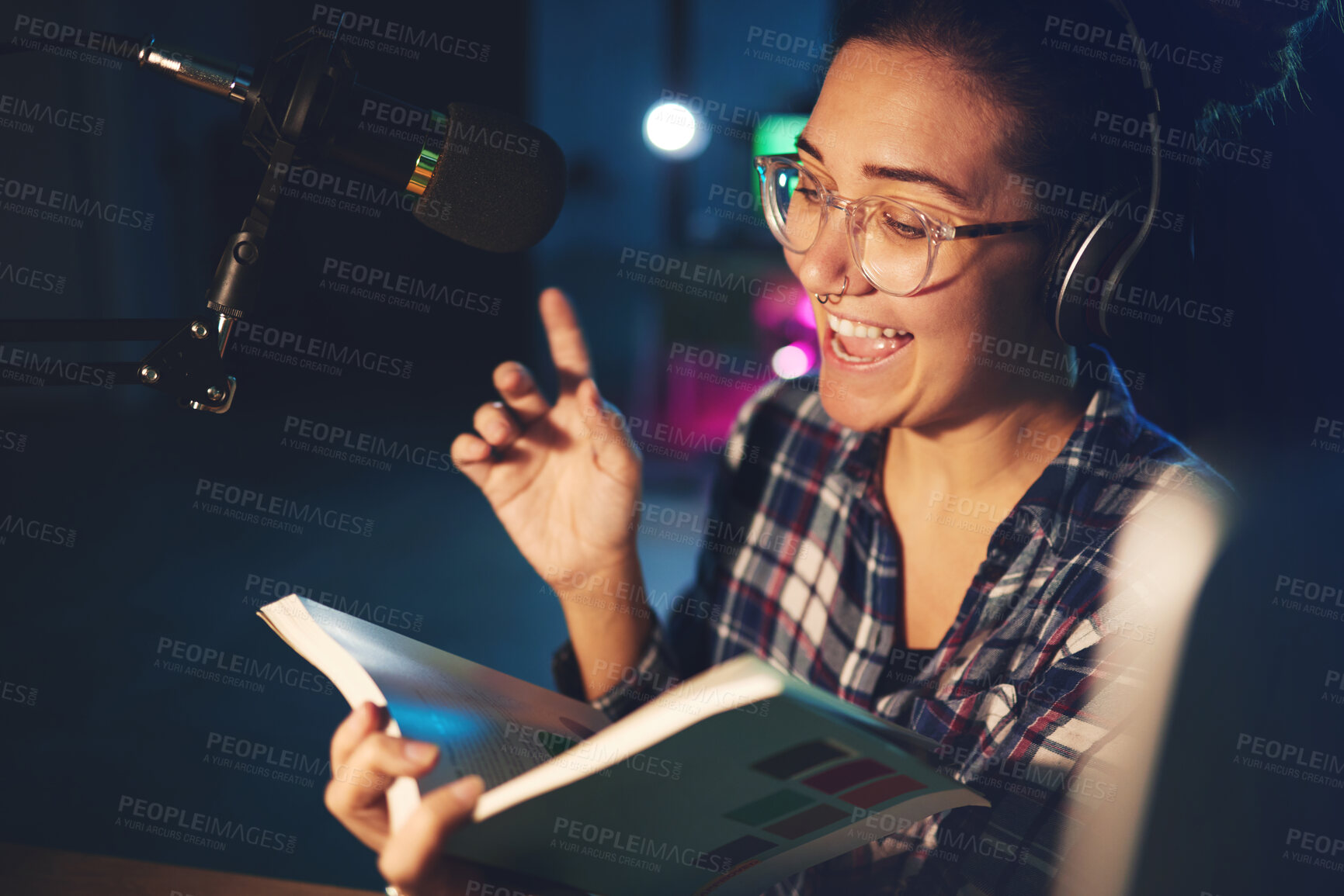 Buy stock photo Radio dj, presenter and woman in a sound production studio reading a book with happiness. Headphones, recording and working female employee with discussion on air for web podcast and books talk