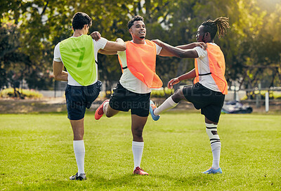 Buy stock photo Sports men, training and outdoor rugby on a grass field with a team stretching legs as warm up. Athlete group together for fitness, exercise and workout for diversity sport with coach and teamwork