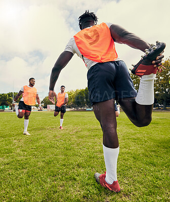 Buy stock photo Sports, men training and outdoor rugby on a grass field with a team stretching legs as warm up. Athlete group together for fitness, exercise and workout for professional sport with coach and teamwork