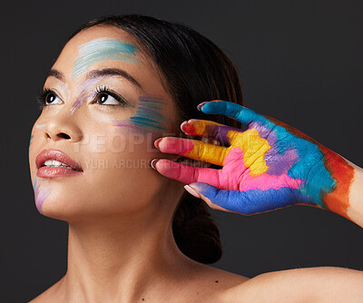 Buy stock photo Woman, hand and beauty with rainbow paint art and face thinking in studio. Creative skin and makeup on female aesthetic model on gray background for lgbtq color inspiration and hope or peace on hands