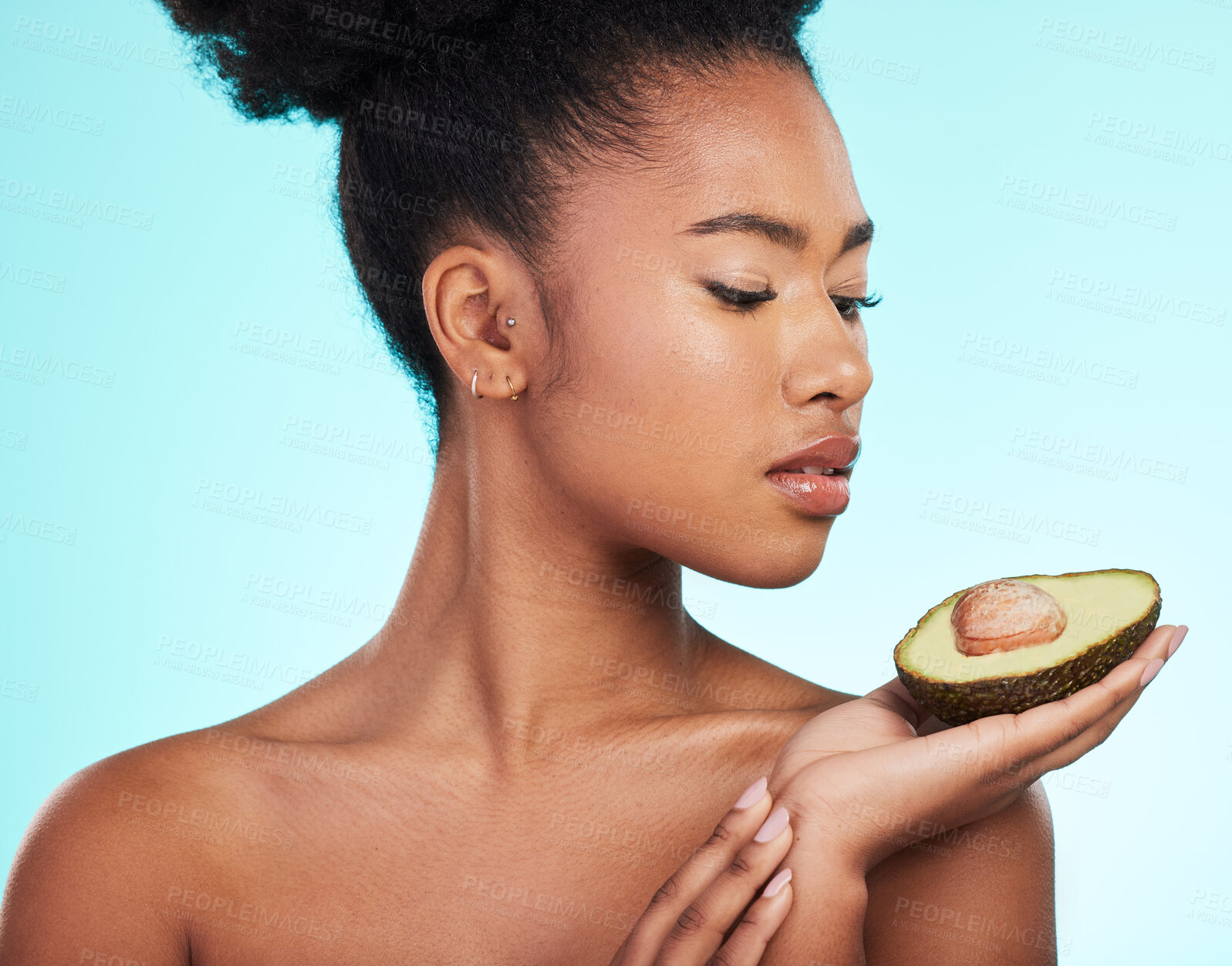 Buy stock photo Avocado, woman and beauty of a young model with skincare, fruit and wellness for diet. Isolated, blue background and studio with a person with facial, cosmetics and healthy food for skin glow