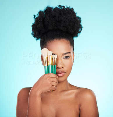 Buy stock photo Portrait, brushes and black woman with skincare, cosmetics and treatment against blue studio background. Face, African American female and lady with cosmetic tools, grooming and confidence with glow