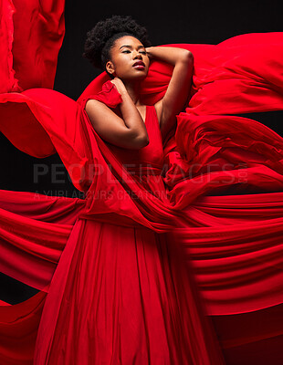 Buy stock photo Beauty, black woman and art in fashion, fabric on dark background and motion in aesthetic movement. Flowing silk, fantasy and artistic, sensual African model in red creative designer dress in studio.