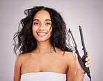 Portrait, happy woman and hair straightener for beauty in studio, transformation or smile on background. Female model, haircare and heat styling equipment of ironing curly hairstyle, texture or tools