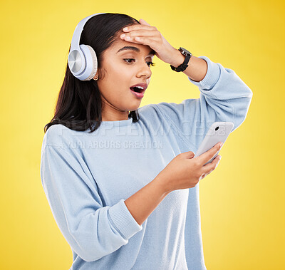Buy stock photo Shock, surprise and woman with phone, headphones and hand on head isolated on yellow background. Social media, music news or exciting online gossip, hispanic girl reading notification on smartphone.