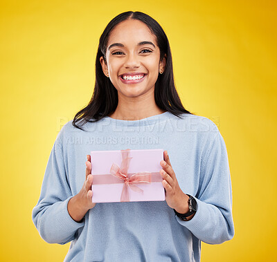 Buy stock photo Happy woman, portrait and gift box in a studio with a smile from surprise present for birthday. Giveaway prize, isolated and yellow background of a young female student feeling positive and cheerful