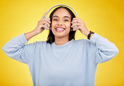 Buy stock photo Laugh, music and headphones with portrait of woman in studio for streaming, online radio and audio. Smile, media and podcast with female on yellow background for technology, listening and connection