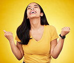 Woman, happy and fist of winner in studio for celebration, achievement deal and lotto success. Excited female model celebrate winning prize on yellow background for lottery, bonus victory and smile 