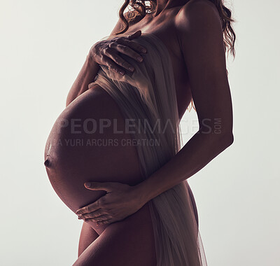 Buy stock photo Woman, pregnant and fabric on stomach in studio with hands, touch and art by white background. Pregnancy model, shadow and mom wellness with cloth for body, belly and silhouette with dark aesthetic