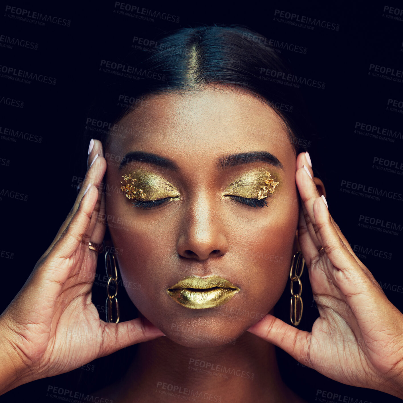 Buy stock photo Woman, face and gold makeup, beauty and glamour with eyeshadow and lipstick on black background. Indian female eyes closed, cosmetics and shimmer with facial, elegant with hands and art in studio