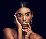 Gold makeup, serious and portrait of a woman isolated on a black background in a studio. Beauty, young and glamorous Indian model posing with creative cosmetics, jewelry and stylish on a backdrop