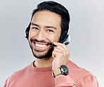 Asian man, portrait smile and headphones with mic for call center or online customer service against a white studio background. Happy male consultant with headset smiling for wireless communication