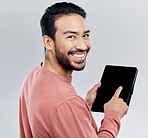 Portrait, smile and Asian man with tablet in studio isolated on a gray background. Face, technology and happy male model with digital touch screen for social media, web scrolling or internet browsing