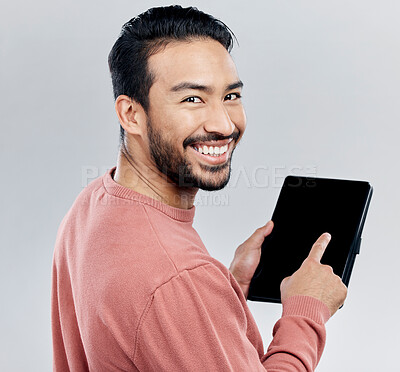 Buy stock photo Portrait, smile and Asian man with tablet in studio isolated on a gray background. Face, technology and happy male model with digital touch screen for social media, web scrolling or internet browsing