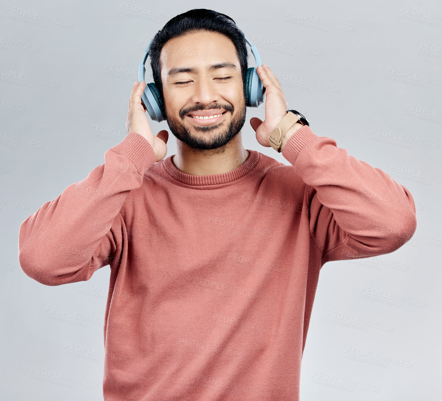 Buy stock photo Listen, happy and Asian man with headphones, streaming music and sounds against a white studio background. Japan, male and guy with headset, listening to radio and podcast for motivation and wellness