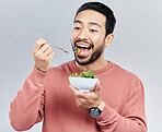 Man, salad and eating healthy food in studio for health or wellness motivation for vegetables. Asian male vegetable bowl for nutrition, diet and benefits for digestion or lose weight white background