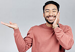 Product placement, happy and a portrait of Asian man showing mockup isolated on a white background. Excited, promotion and guy gesturing to space for branding, advertising and marketing in studio