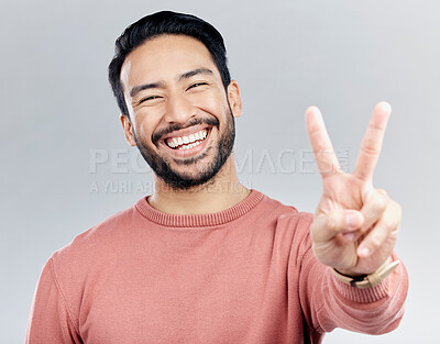 Buy stock photo Portrait, peace sign and laughing Asian man in studio isolated on a gray background. Face, v emoji and happy, smiling or funny, young and confident male model with hand gesture or peaceful symbol.
