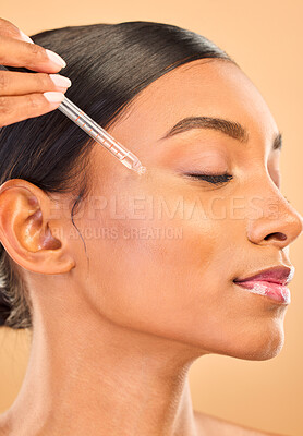 Buy stock photo Skincare, face and woman with serum in studio isolated on a brown background. Dermatology, cosmetics and Indian female model with hyaluronic acid, retinol or essential oil product for healthy skin.