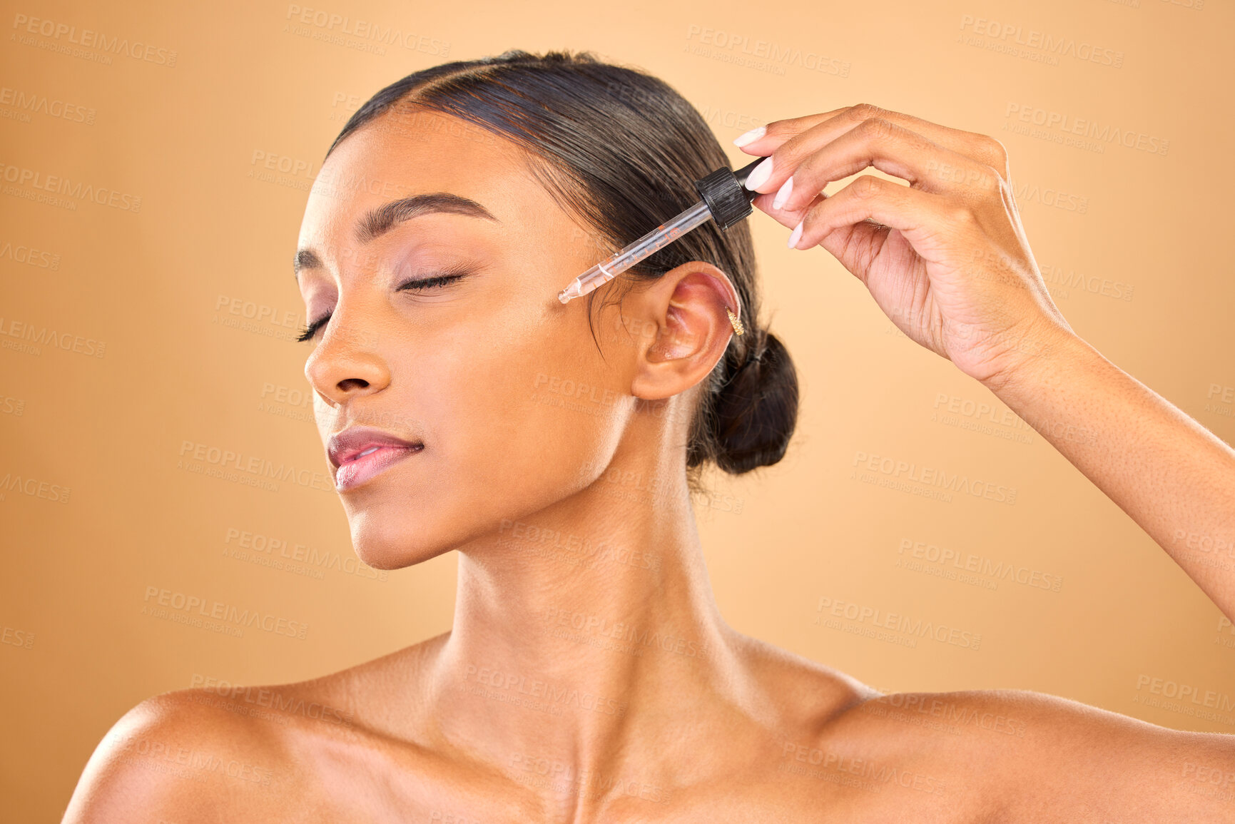 Buy stock photo Face, skincare serum and woman with eyes closed in studio isolated on brown background. Dermatology, cosmetics and Indian female model with hyaluronic acid, retinol or essential oil for healthy skin.