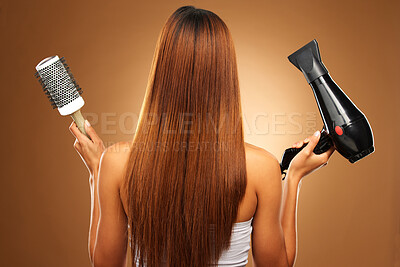 Buy stock photo Hair, brush and hairdryer of woman in studio for growth and color shine or healthy texture. Aesthetic female hands with tools for haircare, self care and hairdresser or salon on brown background
