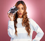 Camera, portrait and woman in studio for photography, wow and surprised against pink background. Lens, photographer and face of girl posing, whistle or emoji while posing for photo on isolated mockup